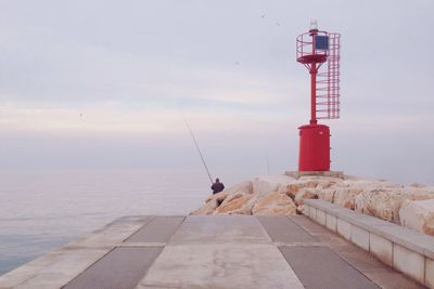 View of lighthouse by sea against sky