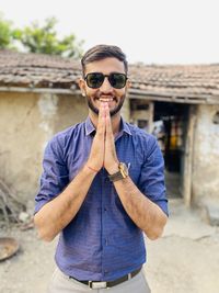 Portrait of young man wearing sunglasses standing outdoors