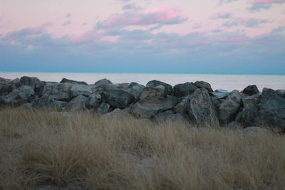 Scenic view of rocks in sea against sky during sunset