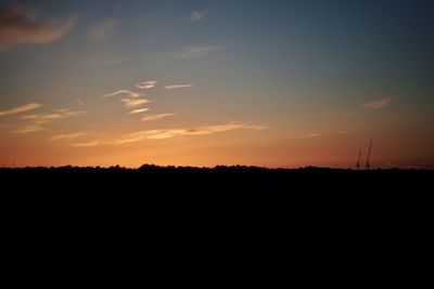 Scenic view of silhouette field against sky during sunset