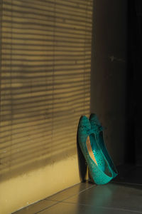 Close-up of shoes on table against wall