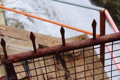 High angle view of rusty metallic fence