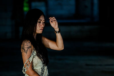 Thoughtful woman standing against blurred background