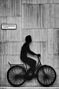 Side view of man riding bicycle sign on wall