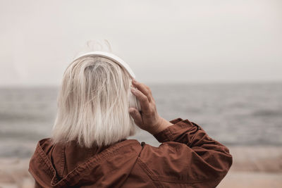 Rear view of woman against sea against sky