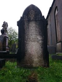 Statue in cemetery against sky