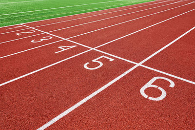 Red running track at stadium with lane numbers