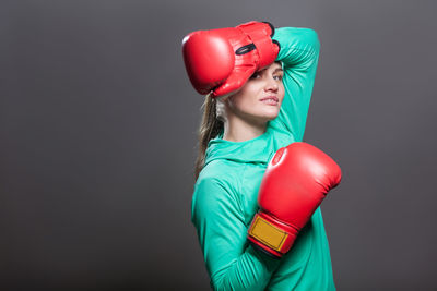 Young woman standing against red background