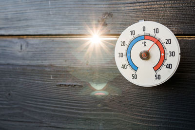 Close-up of information sign on table against sky on sunny day