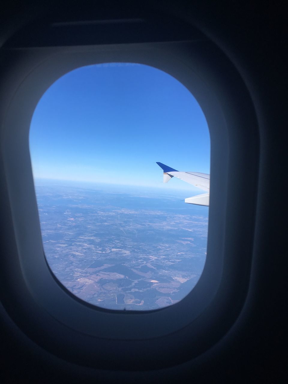AIRPLANE FLYING OVER SEA SEEN THROUGH WINDOW