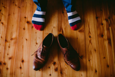 Low section of person standing on wooden floor