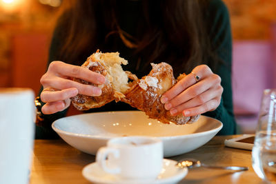 Midsection of woman eating food in restaurant