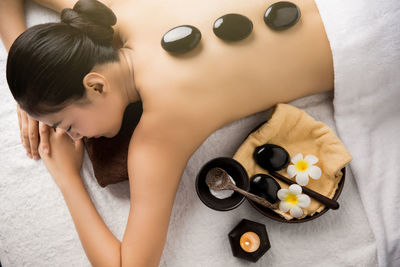 High angle view of woman having lastone therapy at health spa