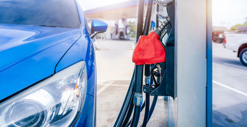 Blue luxury suv car fueling at gas station. refuel fill up with petrol gasoline. petrol pump filling