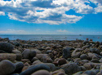 Close-up of pebbles on beach against sky