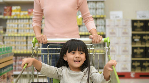 Portrait of happy woman holding ice cream in store