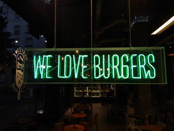 Information sign on illuminated restaurant at night