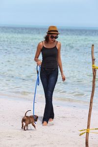 Young woman walking with dog at beach