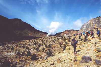 People hiking at mount papandayan against sky