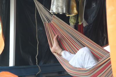 Low section of woman relaxing on hammock