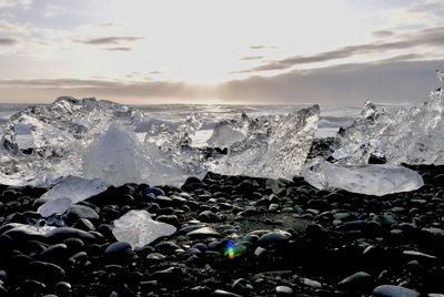 Panoramic view of waves splashing on rocks against sky