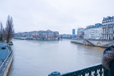 Bridge over seine river by buildings in paris against sky