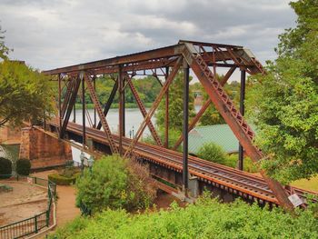 Metallic structure on bridge against sky