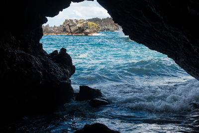 Rock formations by sea against sky