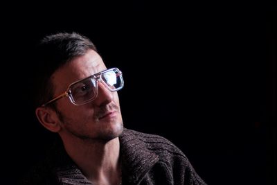 Portrait of young man against black background