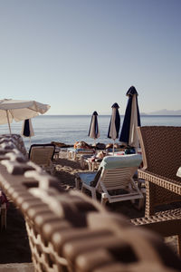 Deck chairs on beach against clear sky