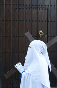 Rear view of person wearing shoes hanging on wood