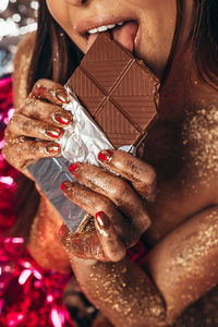 Midsection of woman eating chocolate