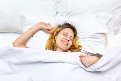 Portrait of young woman lying on bed