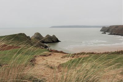 Scenic view of cliffs and sea against clear winter sky