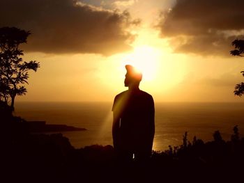 Silhouette of people on beach at sunset