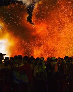 People standing by burning firework