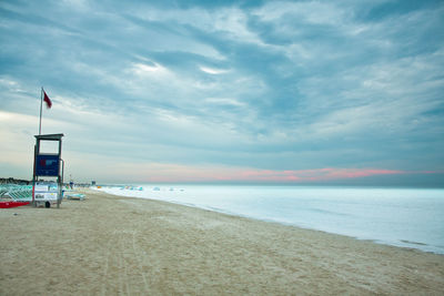 Scenic view of beach against cloudy sky