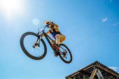 Low angle view of man riding bicycle against sky