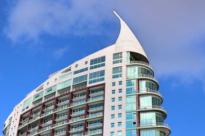 Low angle view of modern building against blue sky