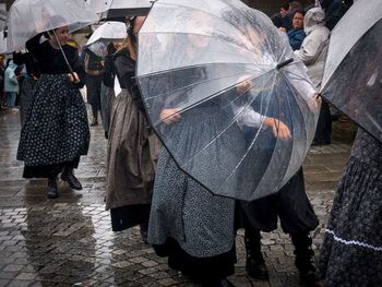 Rear view of people walking on wet street