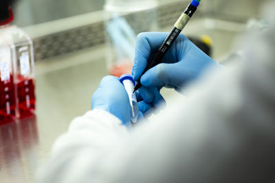 Cropped hand of scientist holding syringe