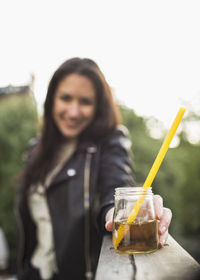 Woman holding elderflower drink on roof garden