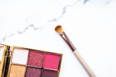 High angle view of make-up brushes against white background