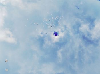 Low angle view of balloons flying against sky