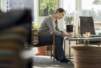 Woman sitting with document at home