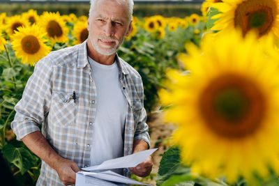 Full length of a man holding sunflower