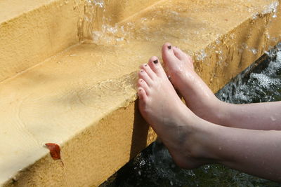 Low section of woman standing on wet steps