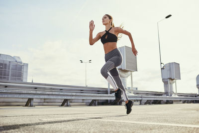 Young woman doing running exercises in the city