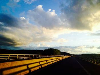 Road against cloudy sky at sunset