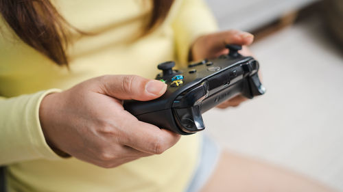 Midsection of woman holding camera